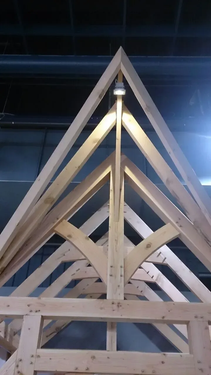 Een houten structuur waar een lamp aan hangt