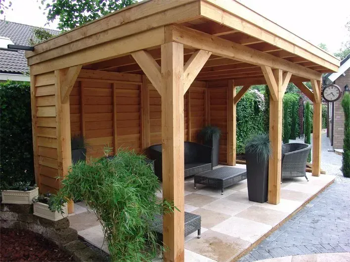 Een houten tuinhuisje met een klok aan de zijkant