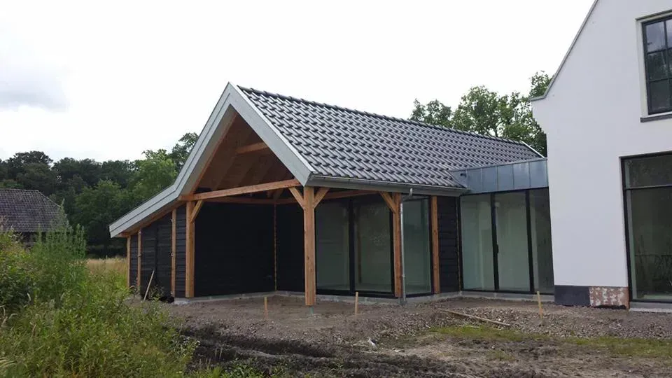 Een wit huis met een houten garage ervoor.
