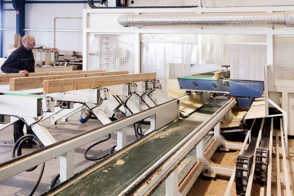 Een man werkt aan een machine in een fabriek