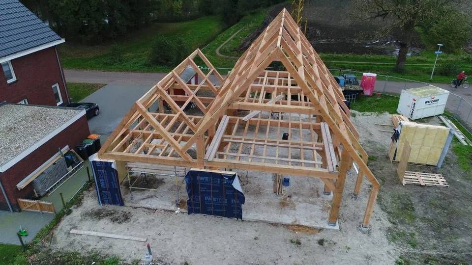 Een luchtfoto van een houten constructie in aanbouw.