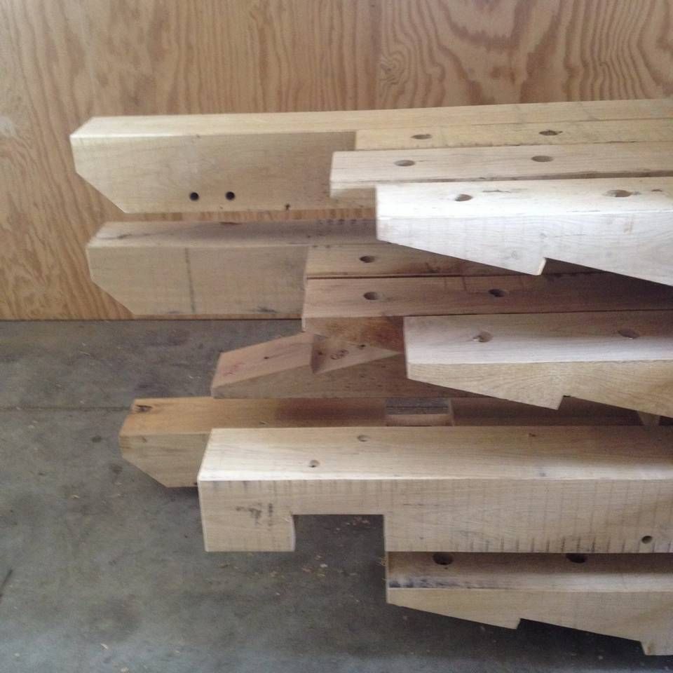 Een stapel houten balken op een betonnen vloer