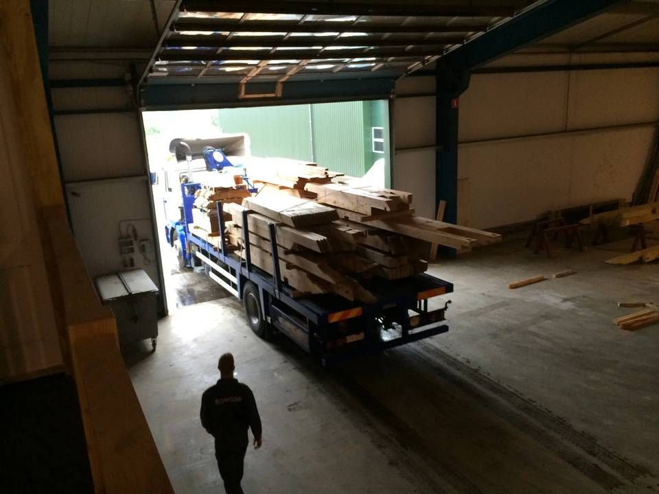 Een vrachtwagen wordt geladen met hout in een magazijn