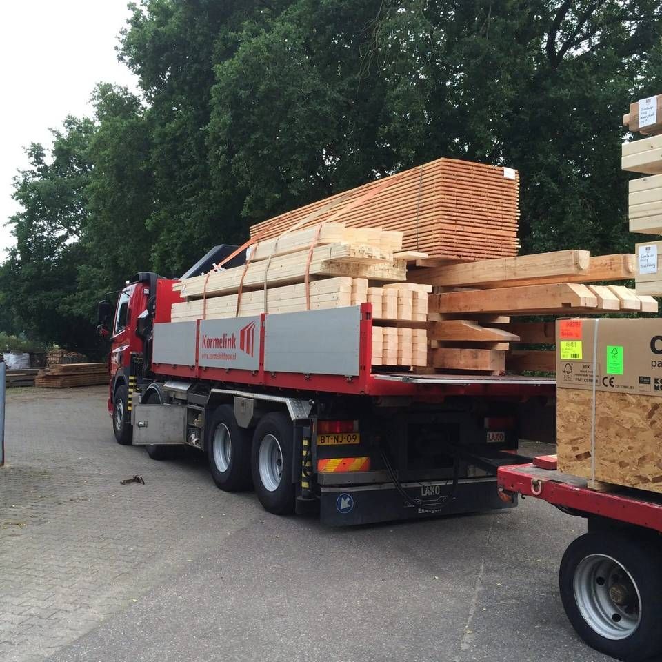 Een grote rood-grijze vrachtwagen met de letter c op de zijkant