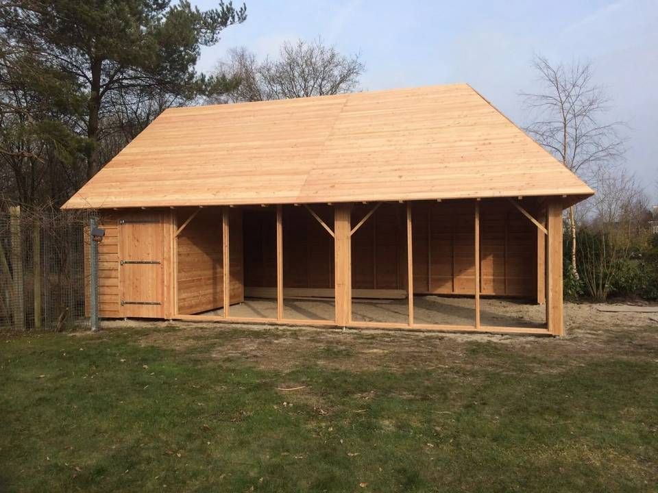 Midden in een grasveld wordt een groot houten gebouw gebouwd