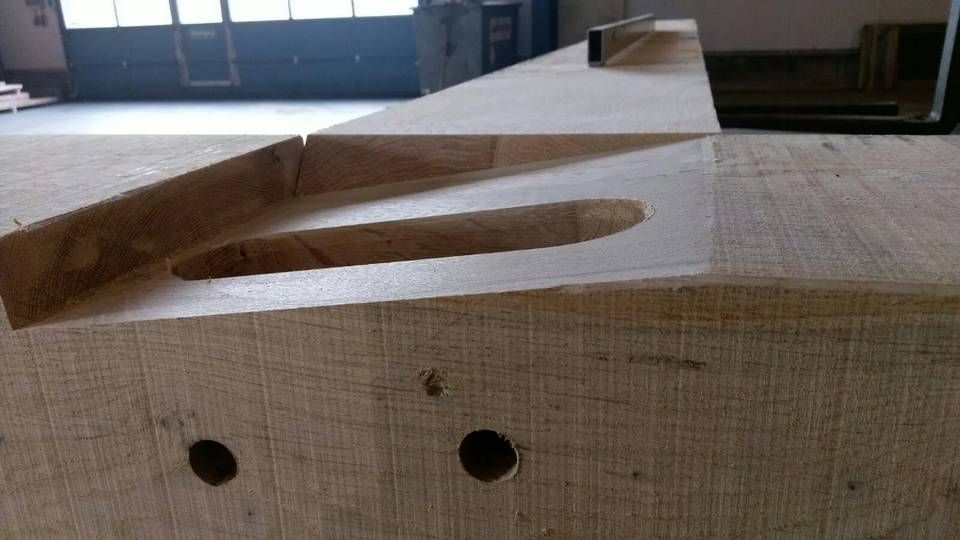 Op een tafel ligt een stuk hout met gaten erin.