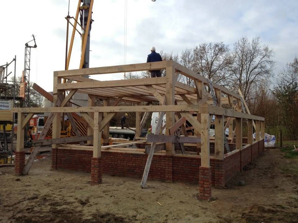Er wordt een houten constructie gebouwd met op de achtergrond een kraan
