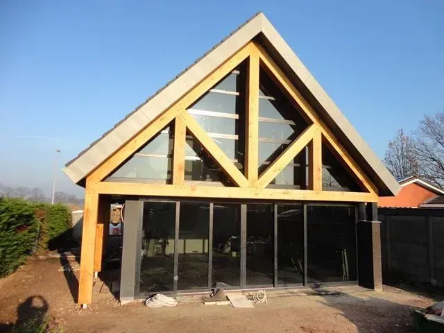 Een huis met een driehoekig dak en veel ramen