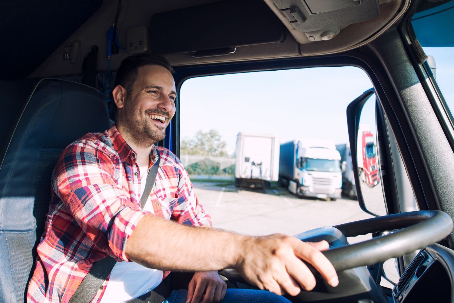 A man is sitting in the driver 's seat of a semi truck.