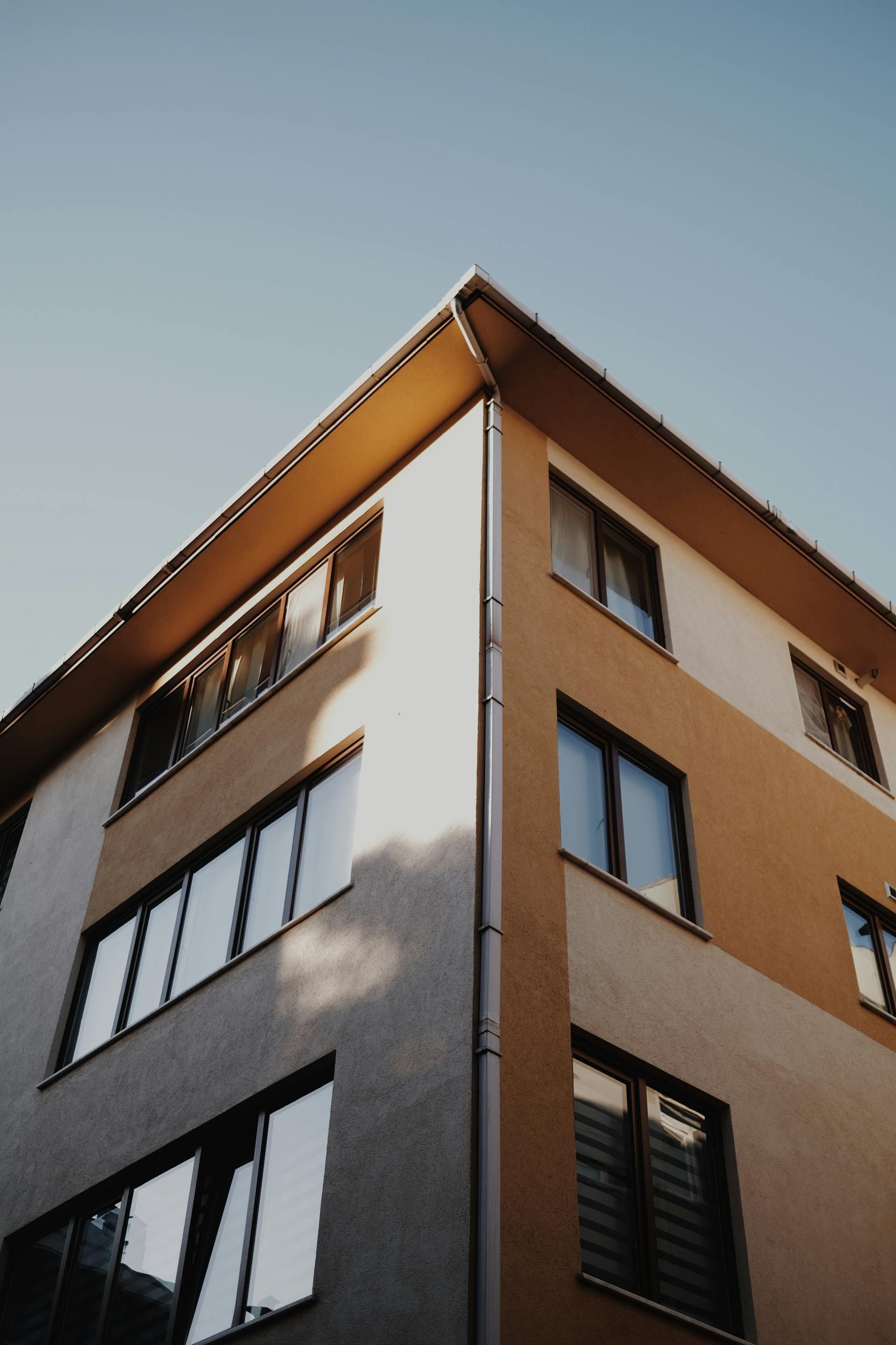Looking up at the corner of a building with many windows