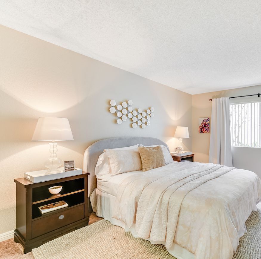 A bedroom with a large bed and two nightstands