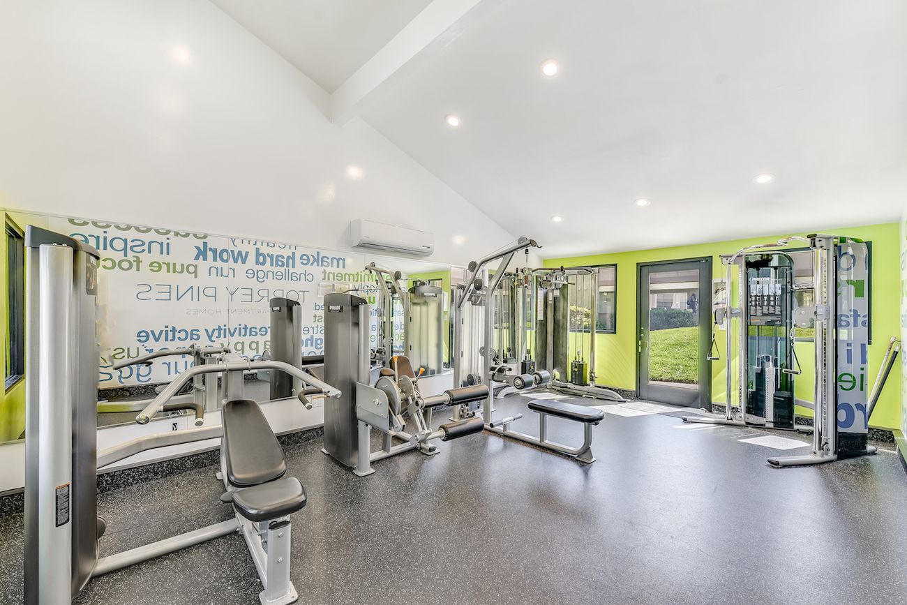 A large gym filled with lots of exercise equipment.