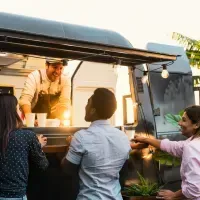 A group of people are standing in front of a food truck.