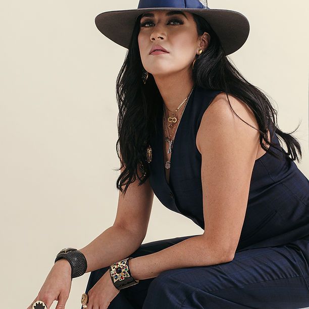 A woman wearing a hat is kneeling down