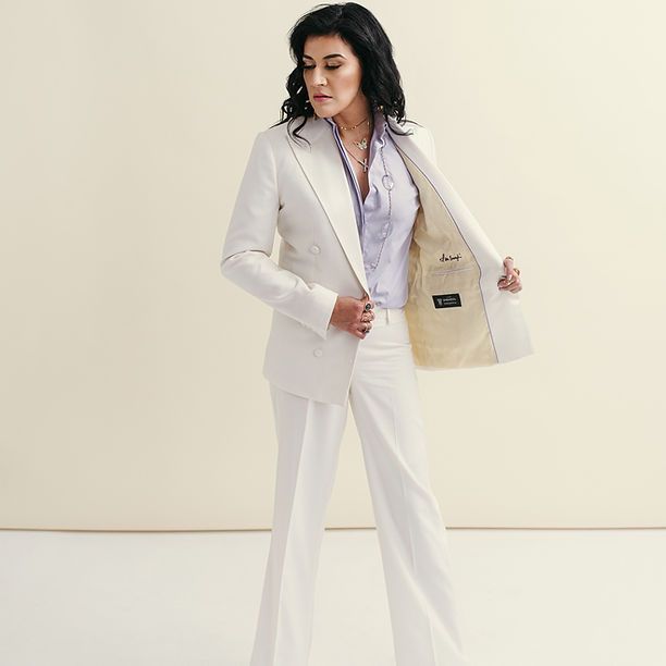 A woman in a white suit has her jacket open