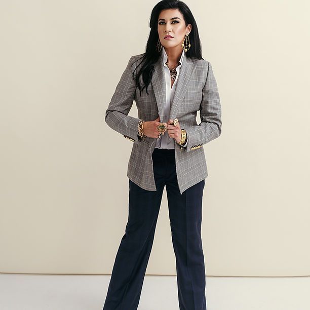 A woman is wearing a grey jacket and black pants