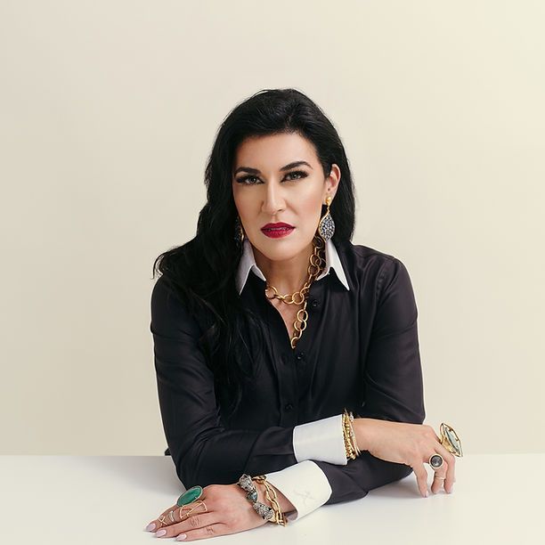 A woman in a black shirt is sitting at a table with her arms crossed