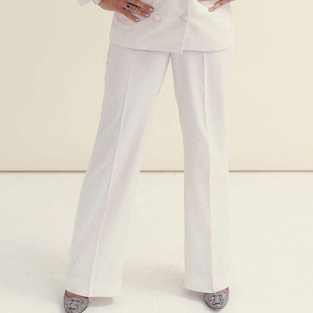 A woman is wearing a white suit and white pants