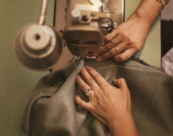 The groom and his groomsmen are posing for a picture in front of the ocean.