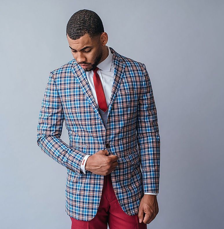 A man is wearing a plaid jacket and red pants