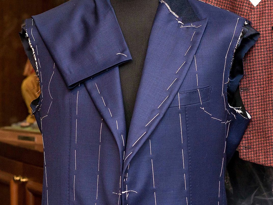 A blue jacket is being made on a mannequin