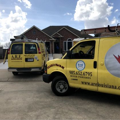 Two a.r.e. vans are parked in front of a house
