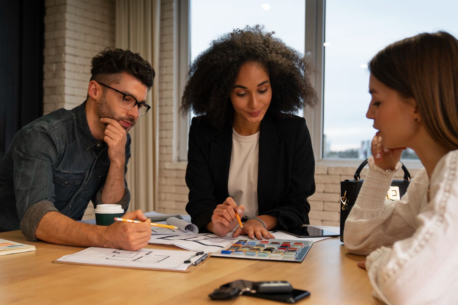 A group of people are sitting around a table having a meeting.