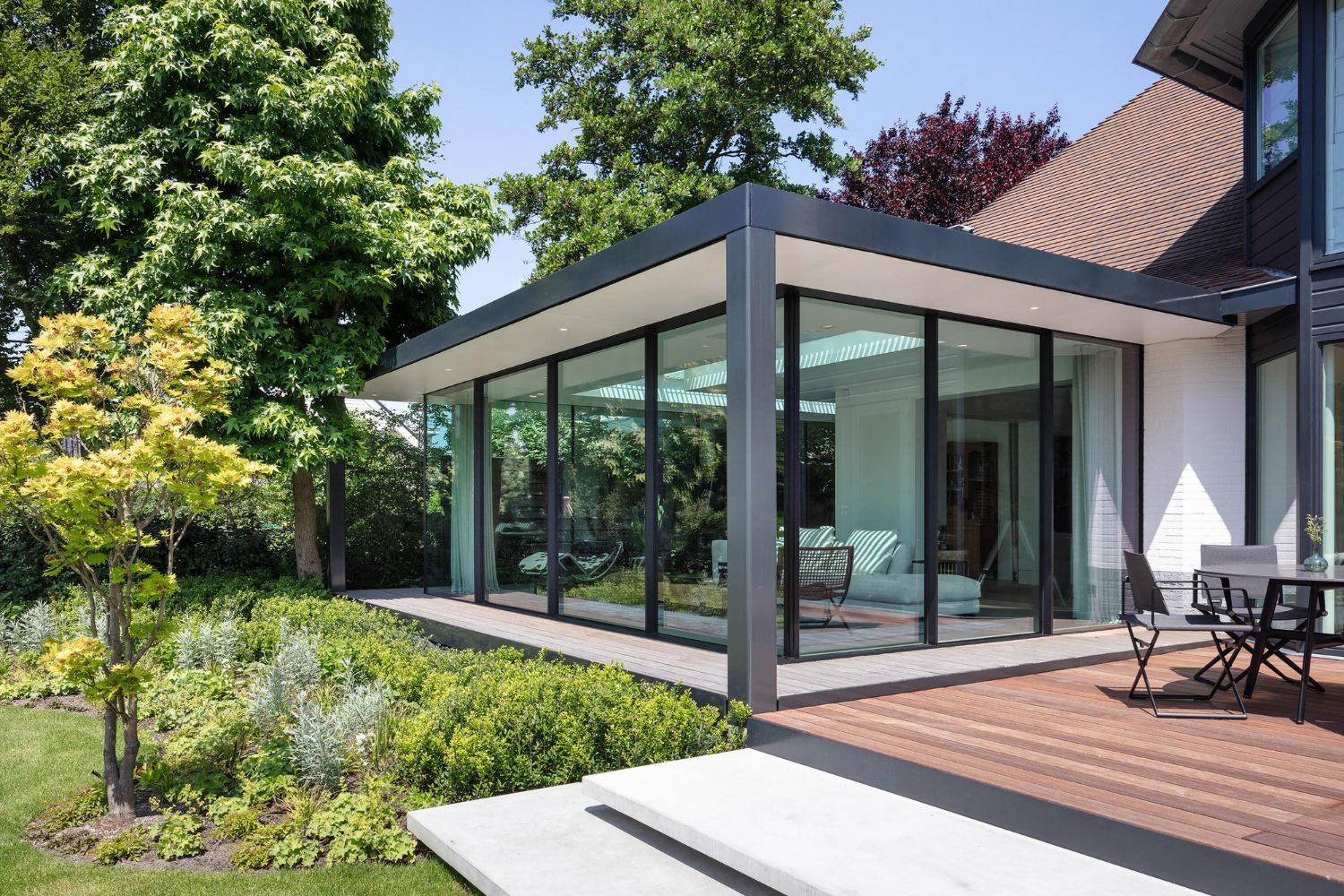 A large house with a lot of windows and a patio in front of it.