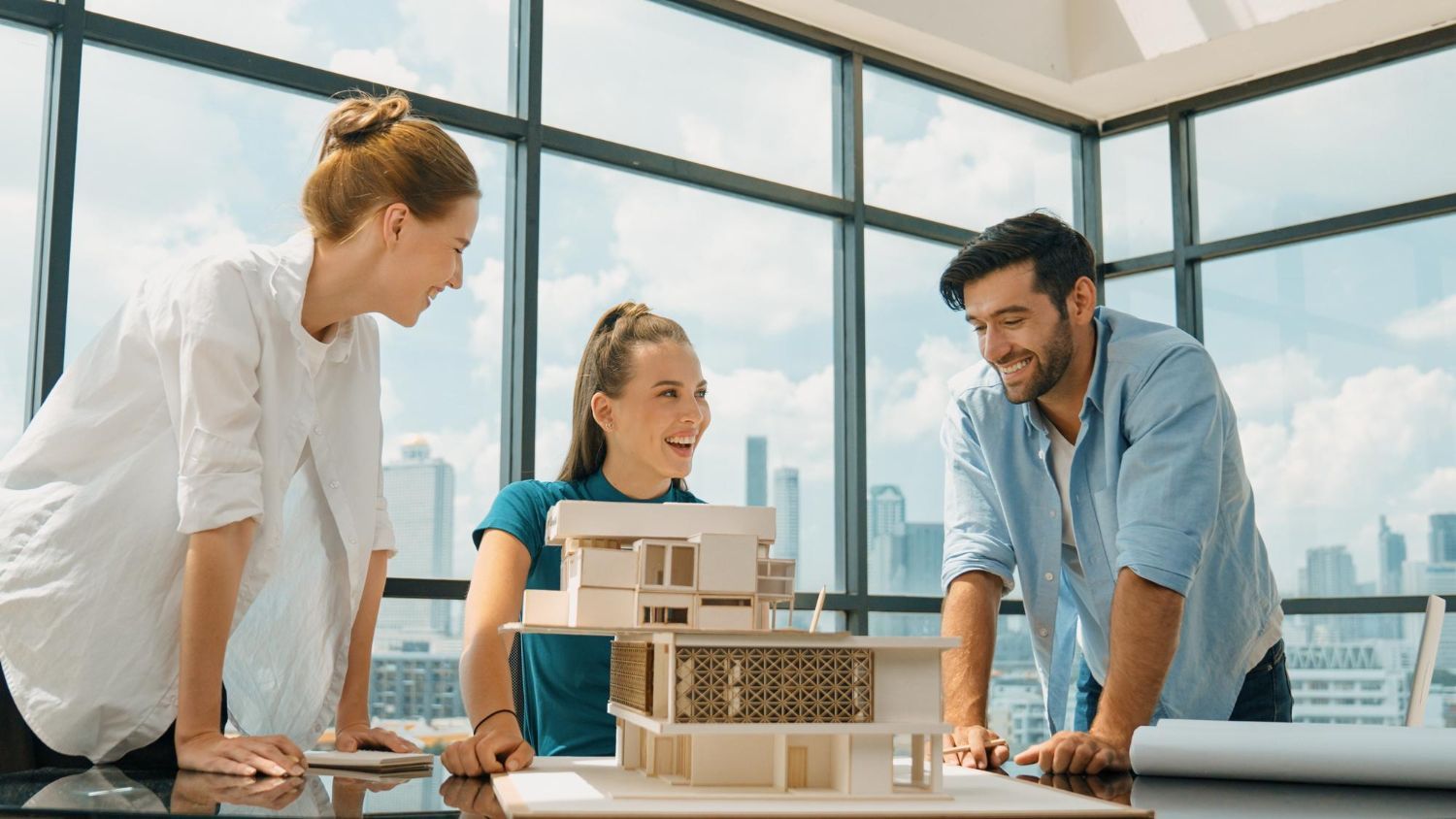 A group of people are looking at a model of a house.