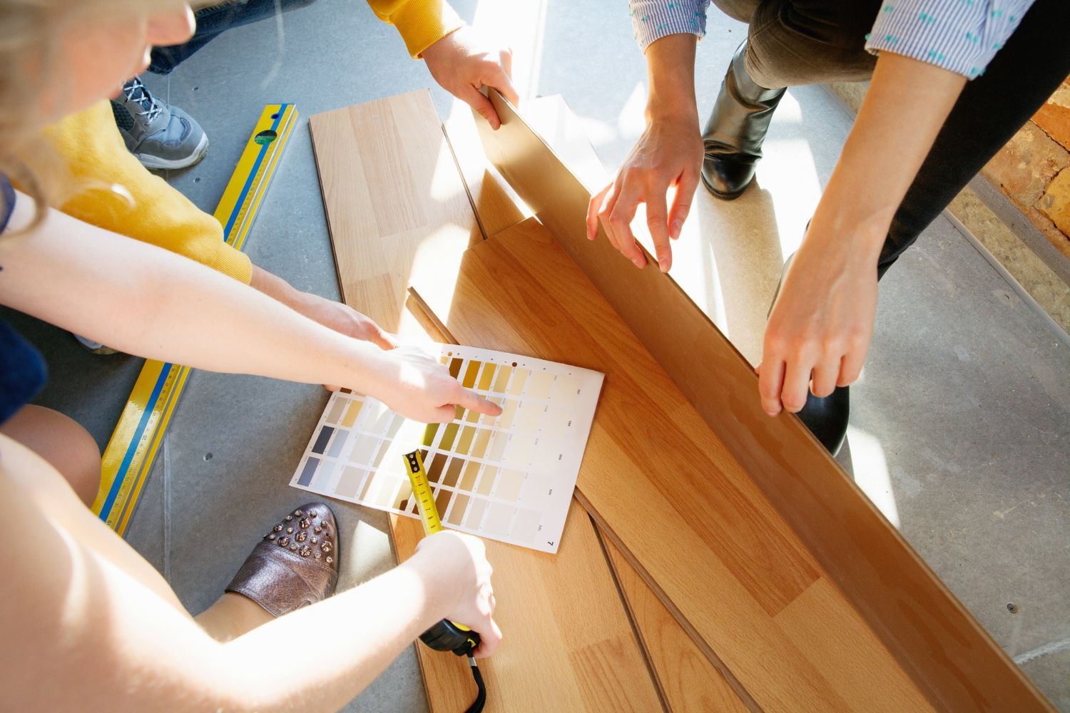 A group of people are working on a wooden floor.