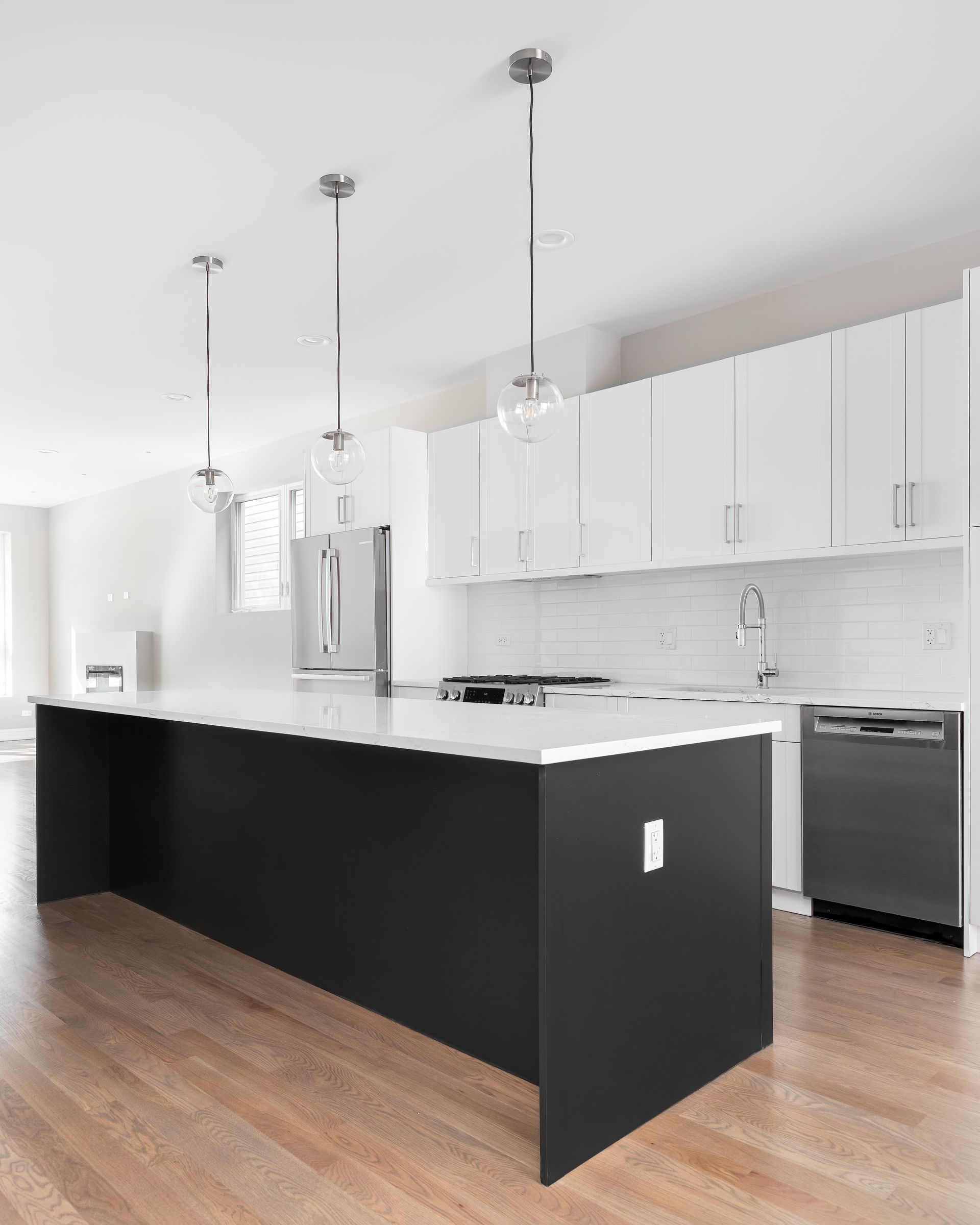 a kitchen with white cabinets and a black island