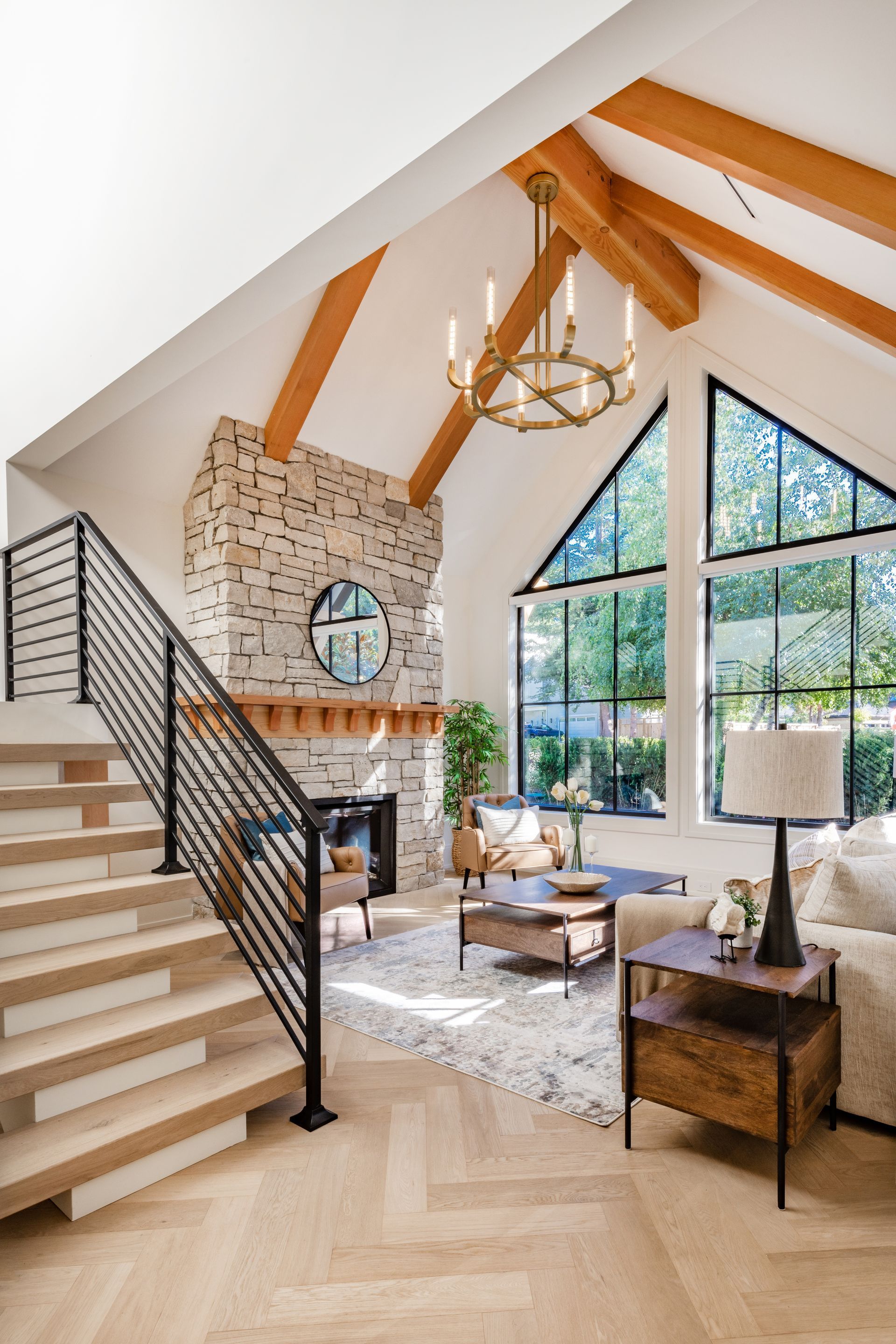 a living room with a stone fireplace and stairs