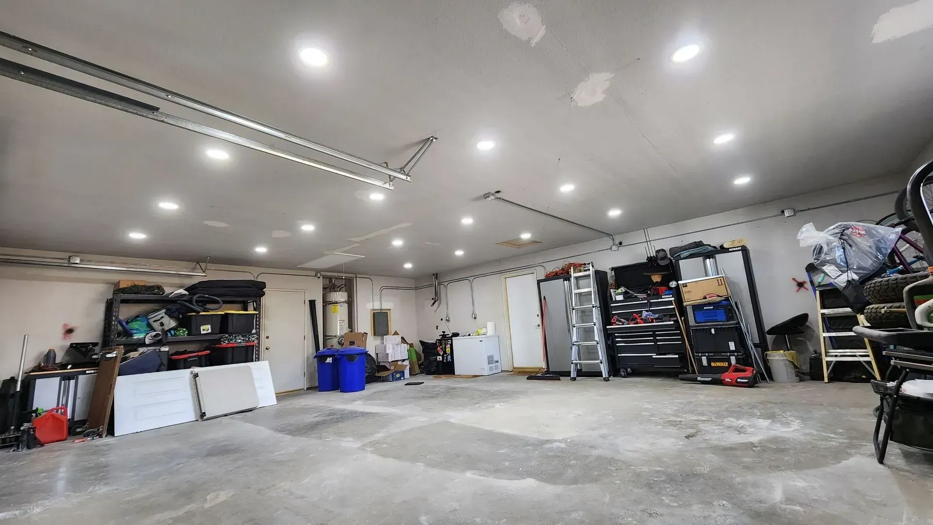 A large empty garage with a garage door open and lots of storage space.