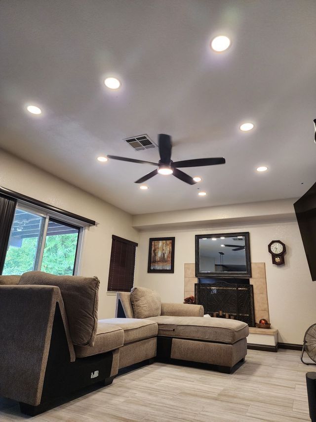 A living room with a ceiling fan and a fireplace