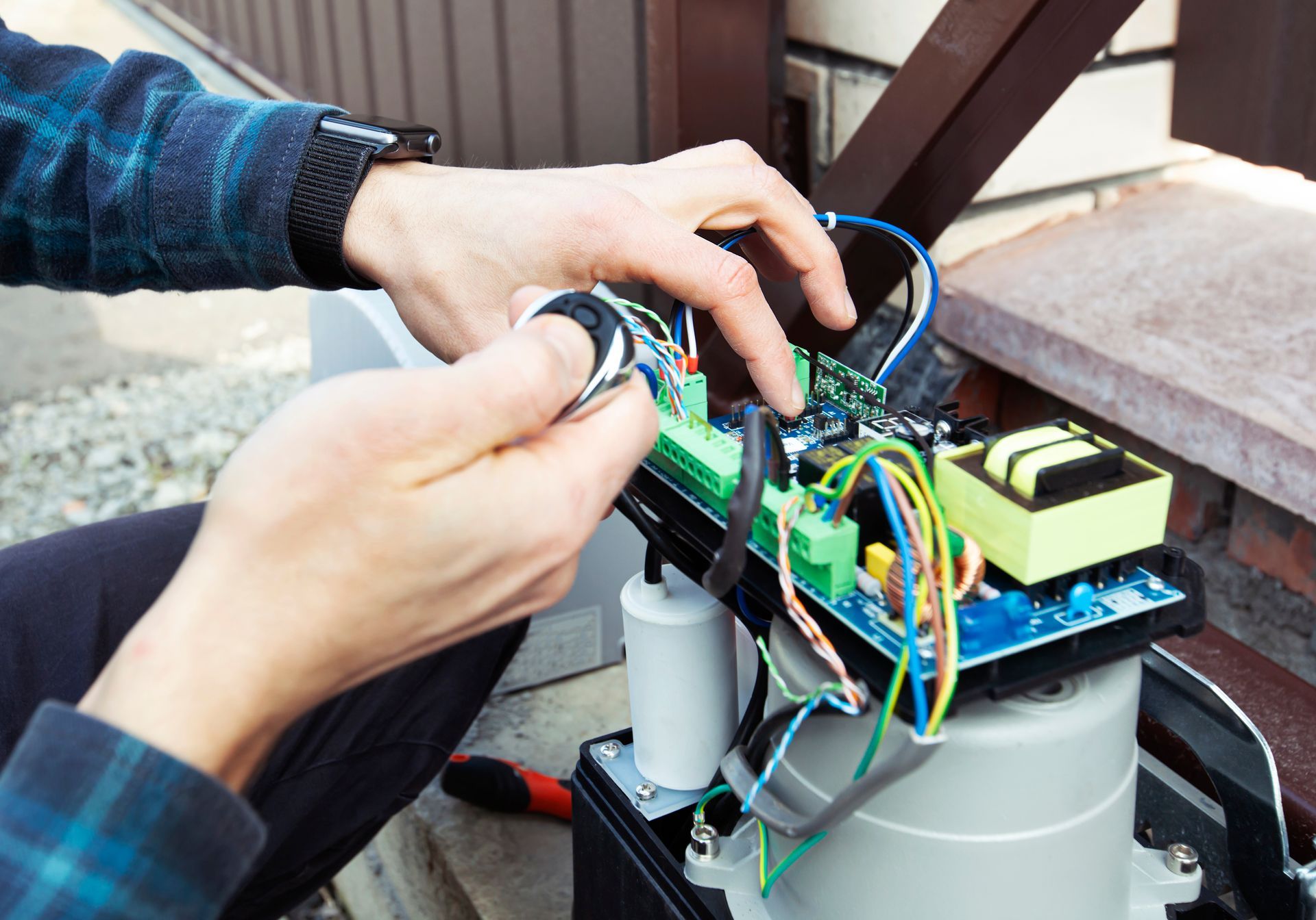 A man is fixing a sliding gate motor