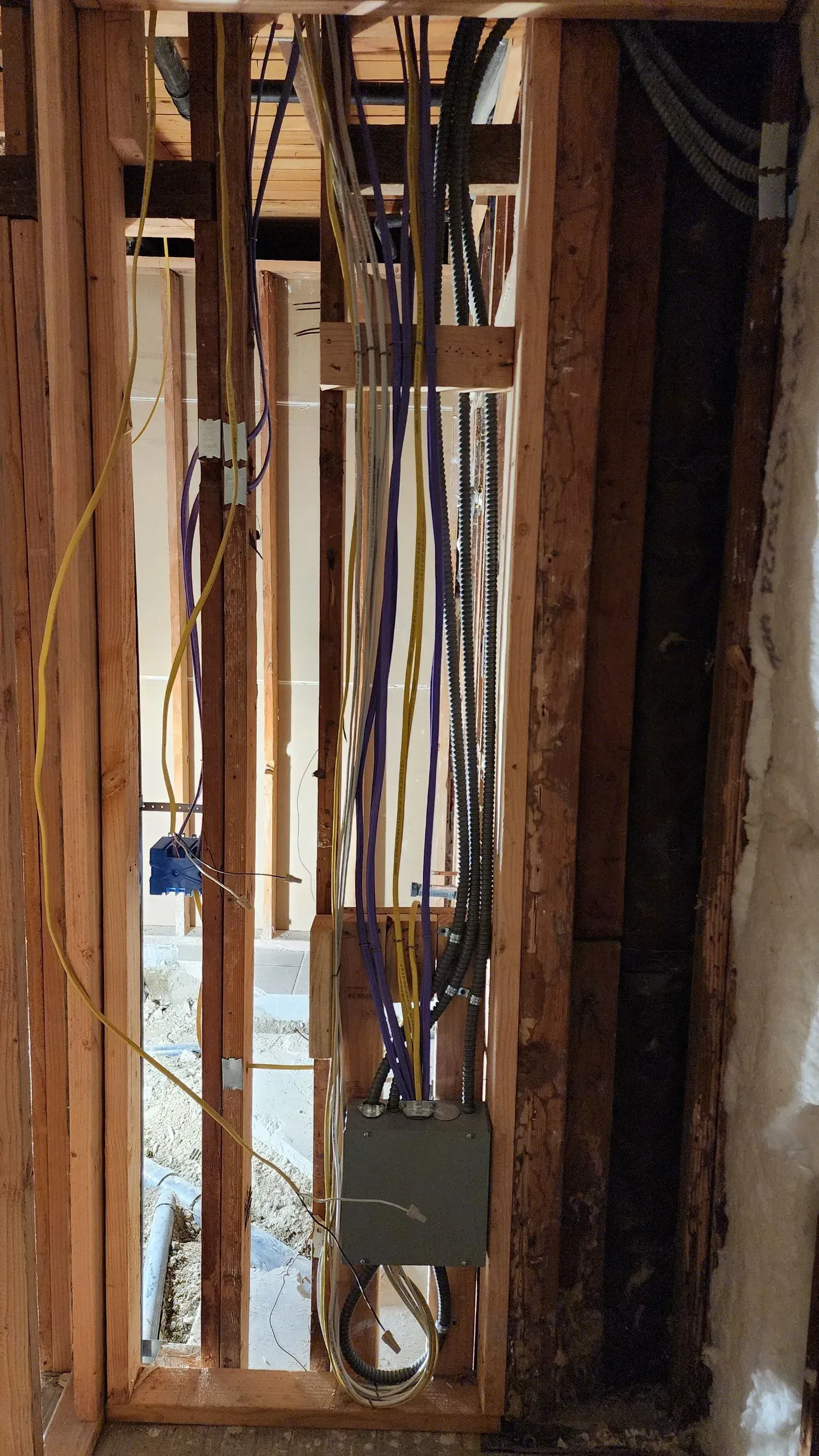 A wooden wall with a lot of wires hanging from it.