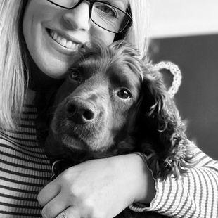 Dog Walker cuddling a happy spaniel during a Muddy Paws Adventures walk in Neston Cheshire