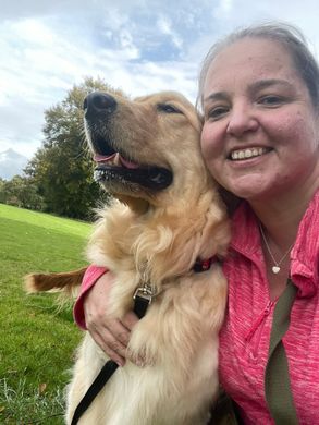 Dog Walker from Muddy Paws Adventures smiling with a golden retriever during a walk in Neston