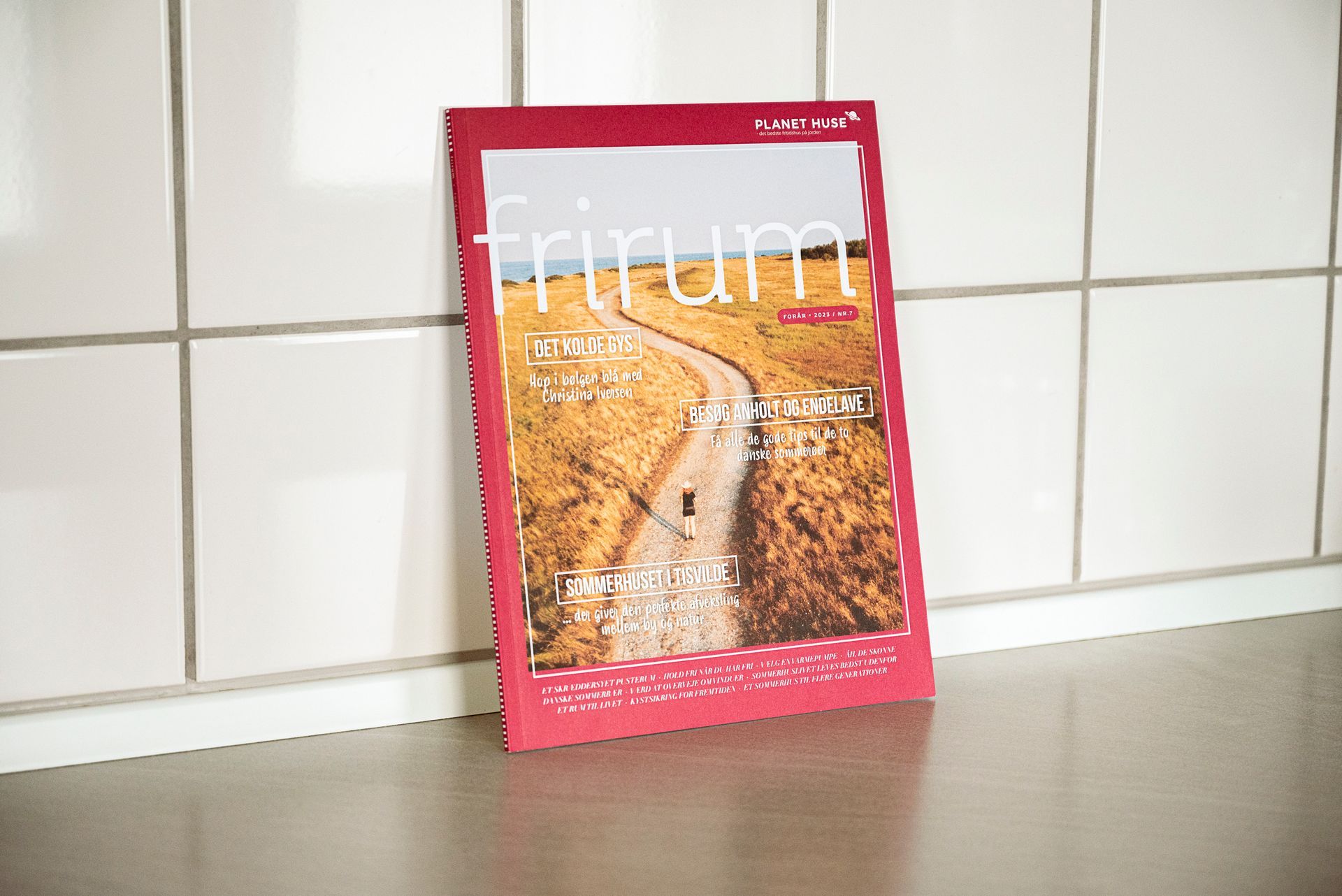 Et foto af magasinet Frirum det står lænet op af en klinkevæg