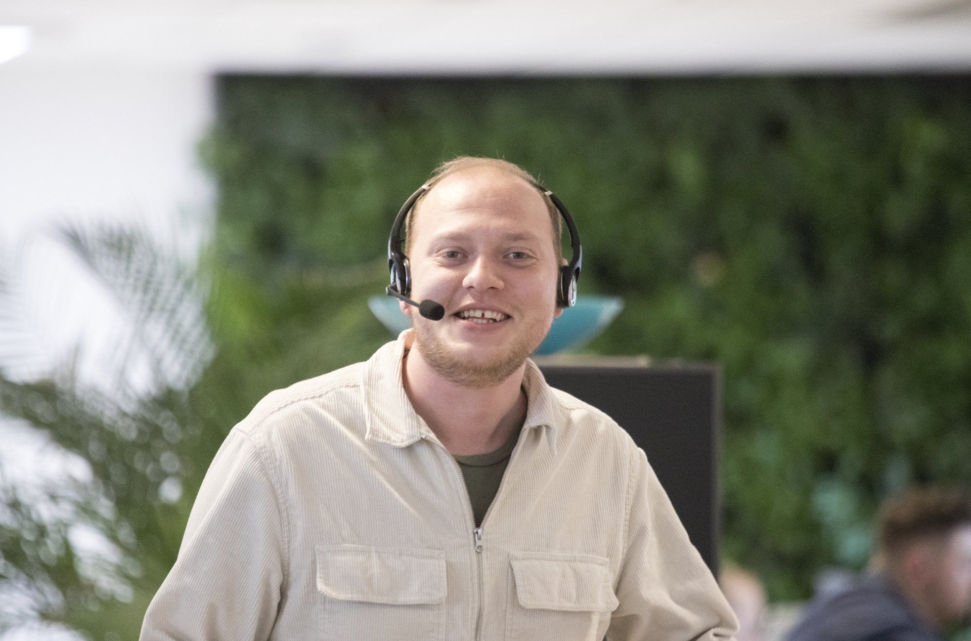 En smilene person i et kontorlokale, der taler i telefon