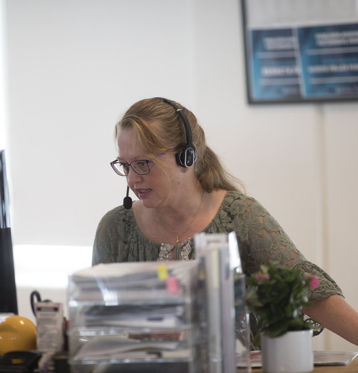 En fokuseret kvindelig medarbejder hos nord, der taler i et headset