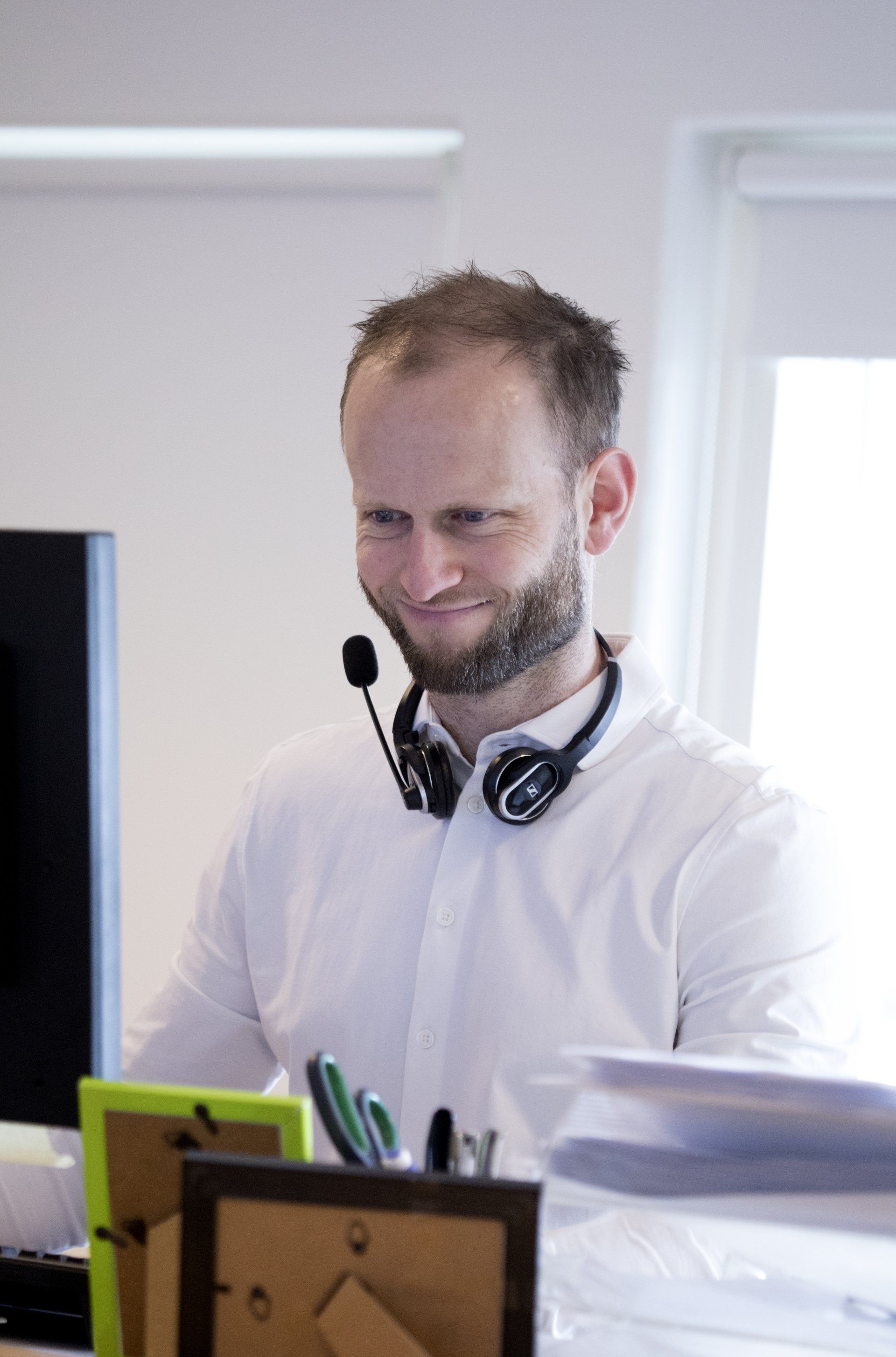Kasper Winther Guldberg arbejder ved computeren med et smil
