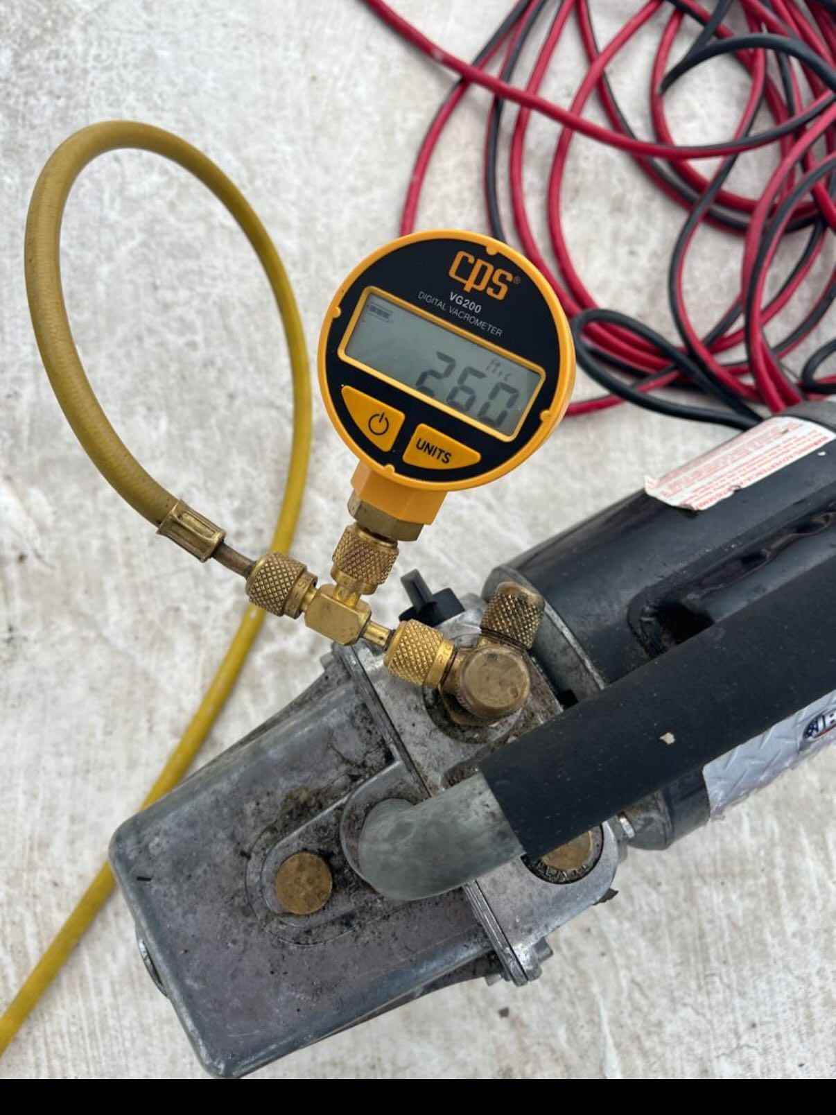 A CPS digital micron gauge attached to a yellow hose and a vacuum pump, displaying a reading of 260.