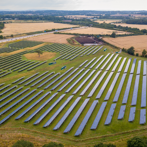 Solar panels against a blue sky with white clouds.