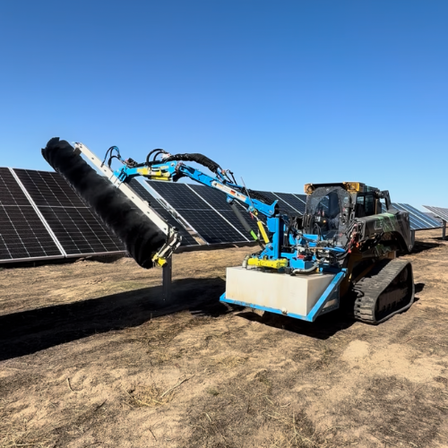 Two workers in safety gear installing solar panels on a rooftop.
