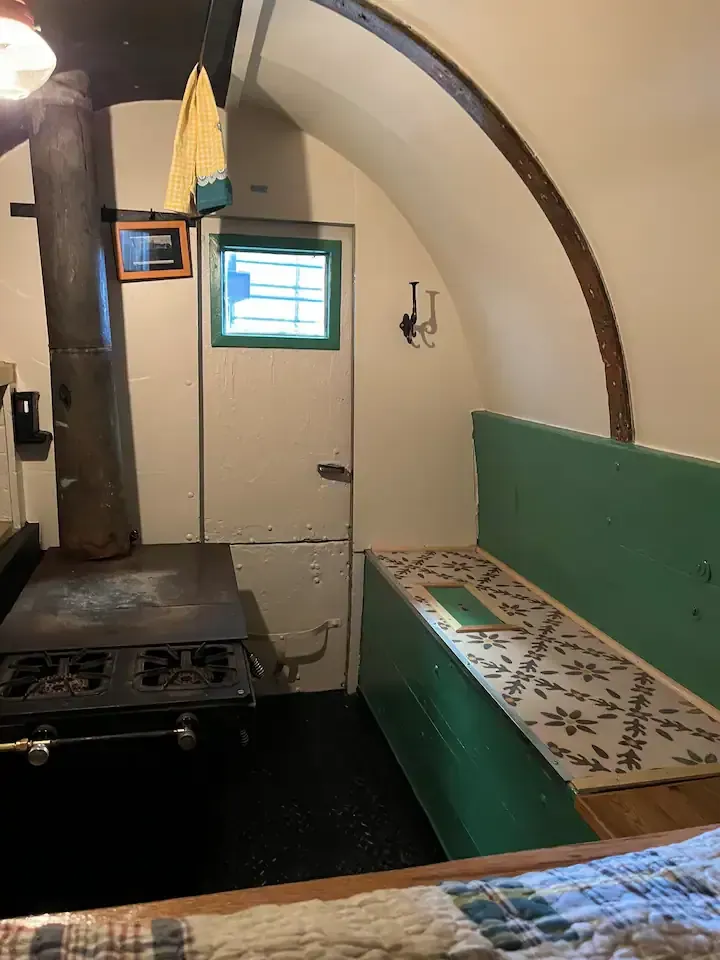 A sheepwagon with a stove and a bench in it