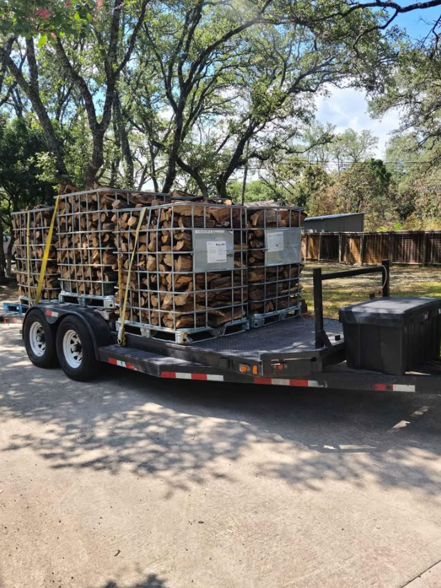 Trailer loaded with stacked wood in large wooden crates, parked outdoors.