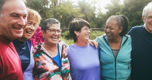 A group of older people are standing next to each other and smiling.