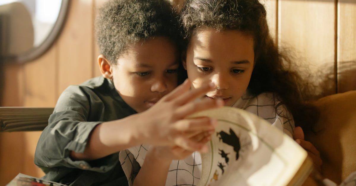 A boy and a girl are reading a book together.