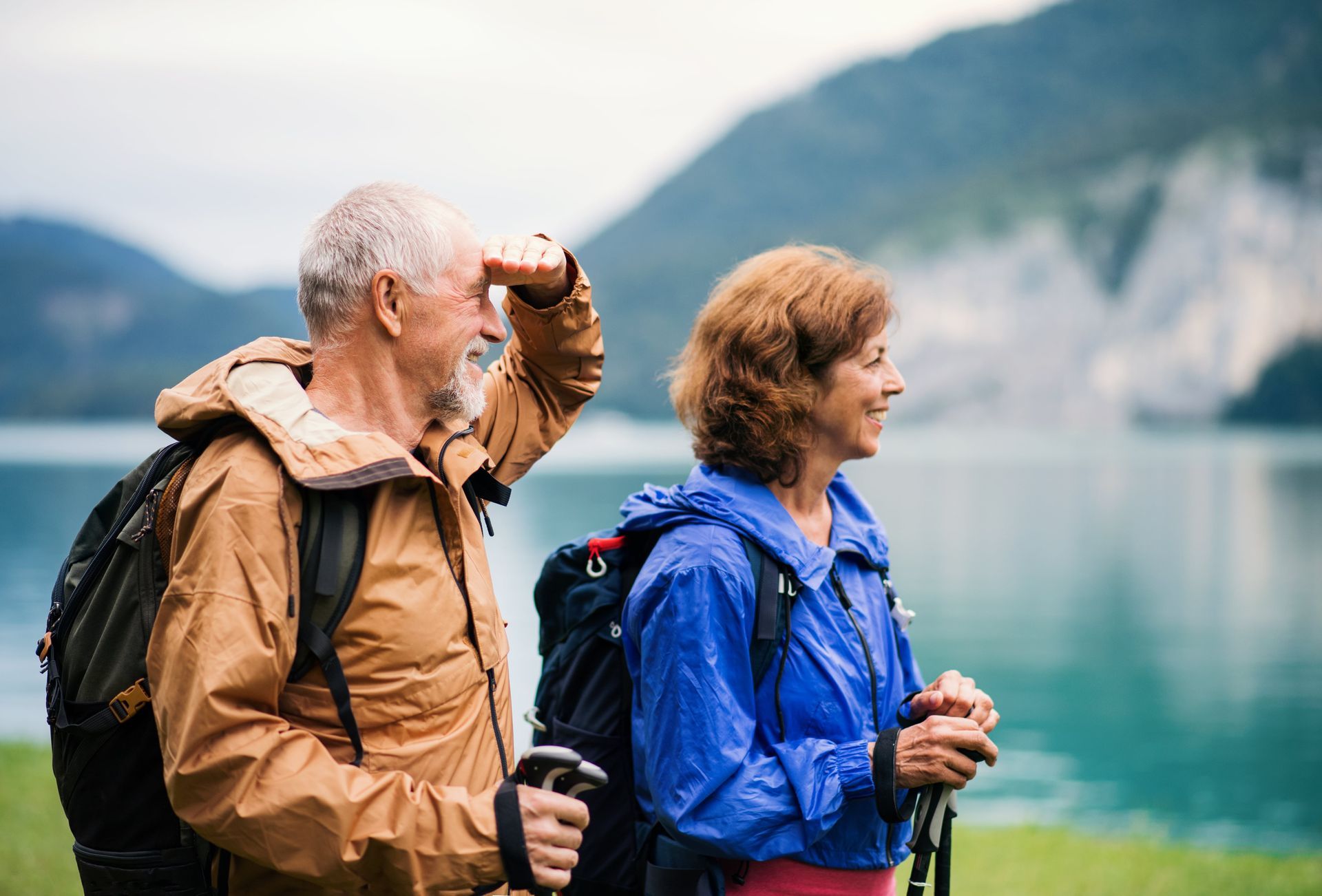 A man and a woman are hiking near a lake.